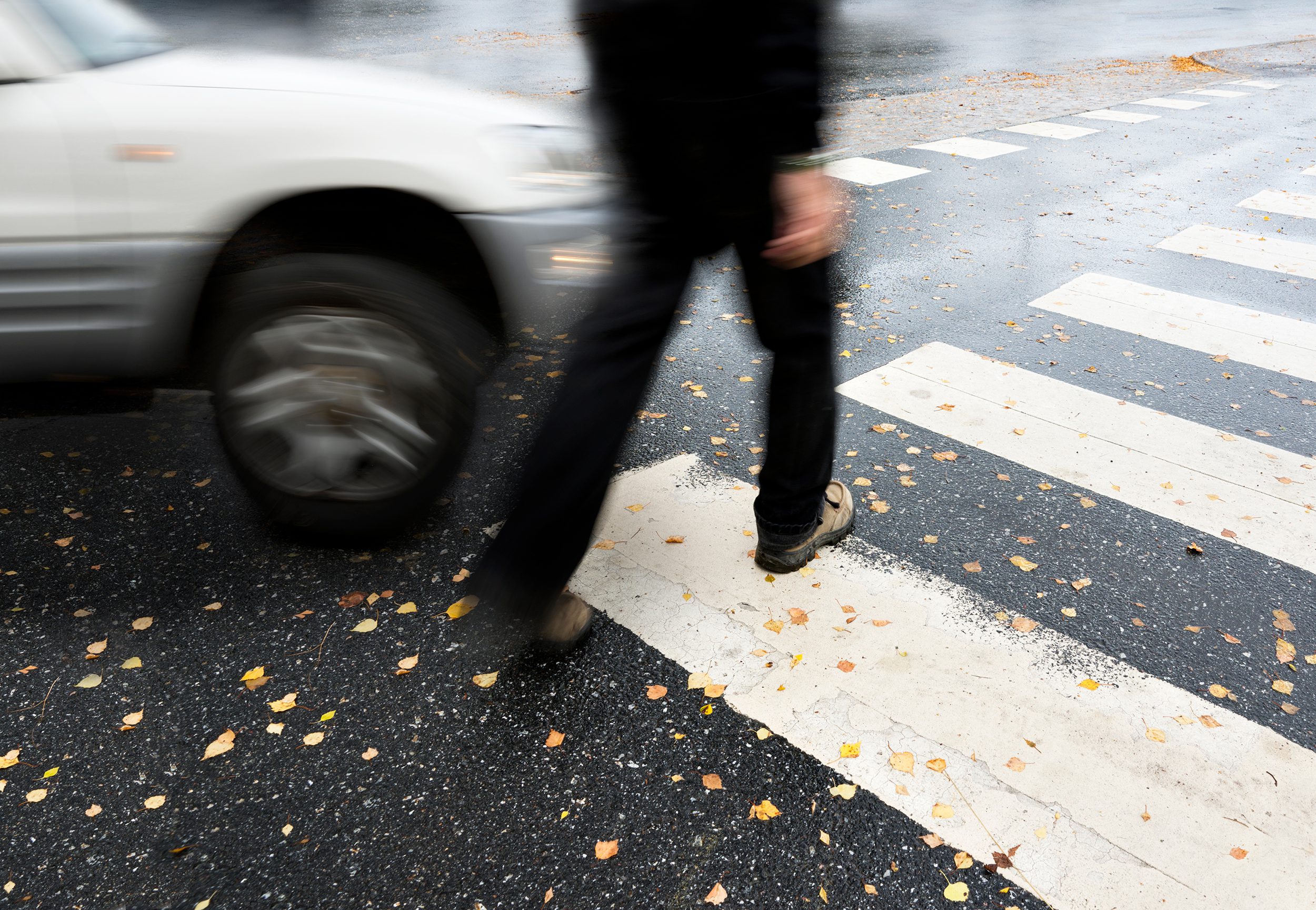 An image of a silver car on a collision course with a pedestrian